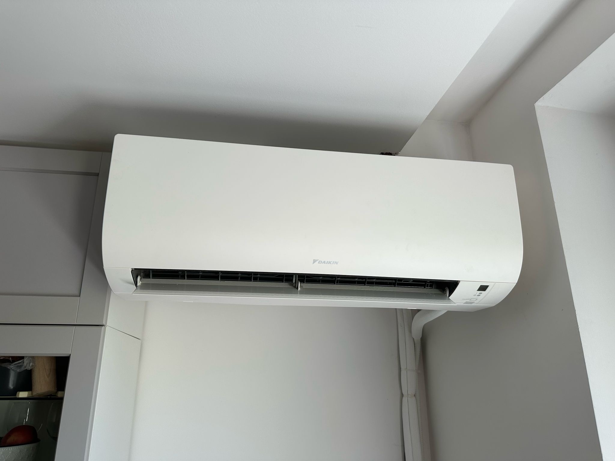 Biela vnútorná jednotka klimatizácie Daikin namontovaná na stene.
